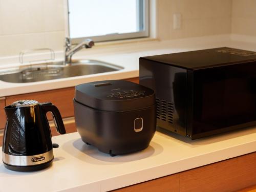 a coffee maker on a counter next to a microwave at Aqua Palace Chatan by Coldio Premium in Chatan