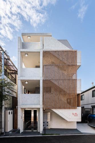 a facade of a building with a wooden wall at Ken's Place Omotesando in Tokyo
