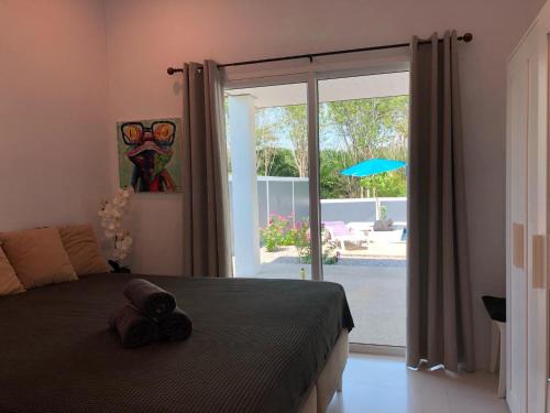 a bedroom with a bed and a sliding glass door at Pinky Bungalow Resort & Villa - SHA Extra Plus in Ko Lanta