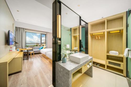 a bathroom with a sink and a desk at Echarm Hotel Kunming Changshui International Airport in Kunming