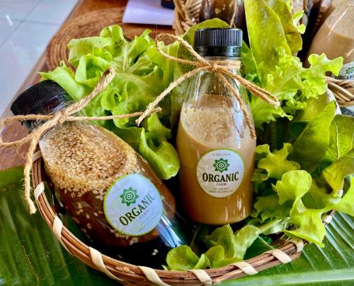 a basket of food with lettuce and a bottle of orange juice at Ta Thai Cooking & Stay in Ban Khlong Tan