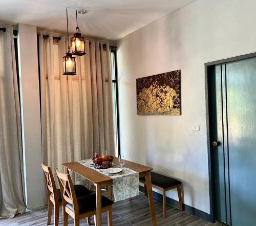 a dining room with a wooden table and chairs at Ta Thai Cooking & Stay in Ban Khlong Tan