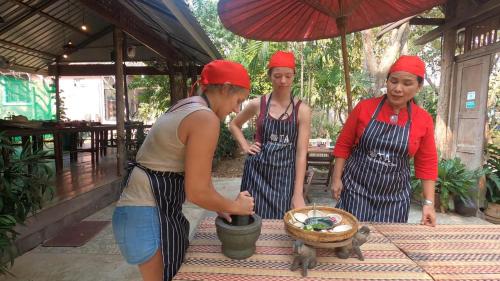 a group of three women standing next to a basket at Ta Thai Cooking & Stay in Ban Khlong Tan