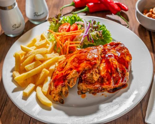 a white plate of food with meat and french fries at The Select Inn Gosford in Gosford