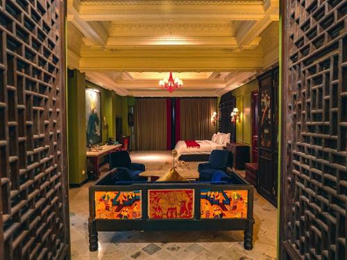 a room with a bed and a table and chairs at House of Tugu, Old Town Jakarta in Jakarta