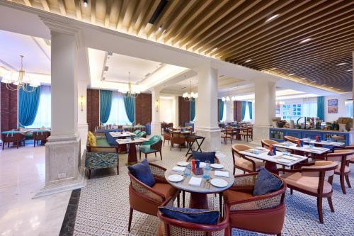 a restaurant with tables and chairs and a bar at Sarovar Premiere Amritsar in Amritsar