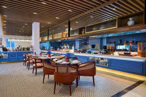 a restaurant with a long table and chairs and a bar at Sarovar Premiere Amritsar in Amritsar
