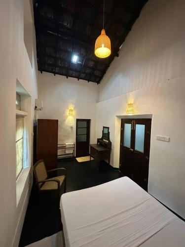 a bedroom with a bed and a desk and a chair at Tipsy Ceylon in Rathgama