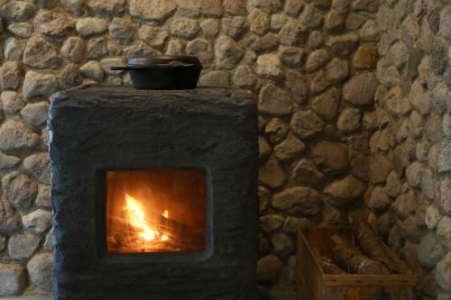 a stone fireplace with a pot on top of it at kamenos Luxury Resort With Beautiful Scenery Hiji in Hiji