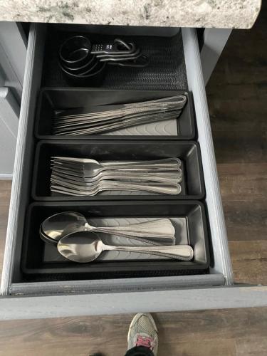 a drawer filled with silver utensils and a persons foot at Casa localizada muy cerca del estadio, 8 minutos del centro y muchos lugares mas, No se permiten fiestas , o fumar in Milwaukee