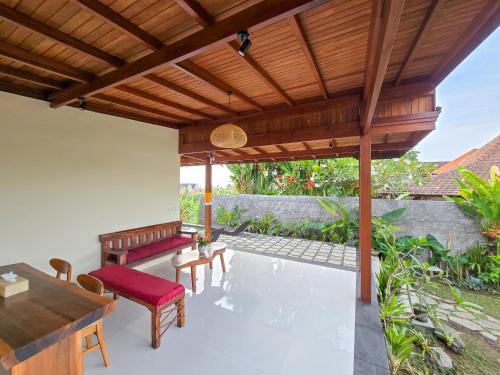 an outdoor patio with a wooden pergola at Uma Jala Villa Ubud in Ubud
