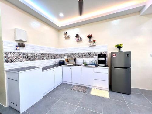 a kitchen with white cabinets and a refrigerator at Mountain View 606 in Langkawi Islands