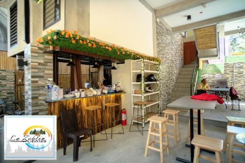 a bar in a restaurant with a table and stools at La Zeblin Beach House in Zambales