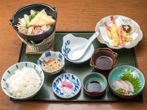 a tray of food with rice and bowls of food at Tabist Miya Yokkaichi Suizawa in Suizawa