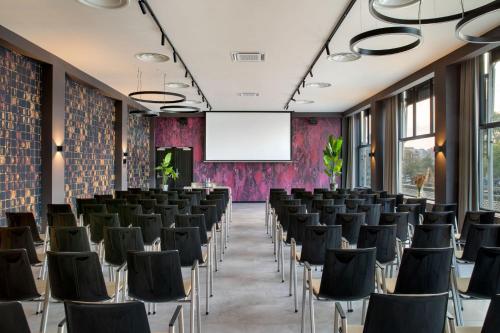 a conference room with chairs and a projection screen at Apollo Hotel Amsterdam, a Tribute Portfolio Hotel in Amsterdam