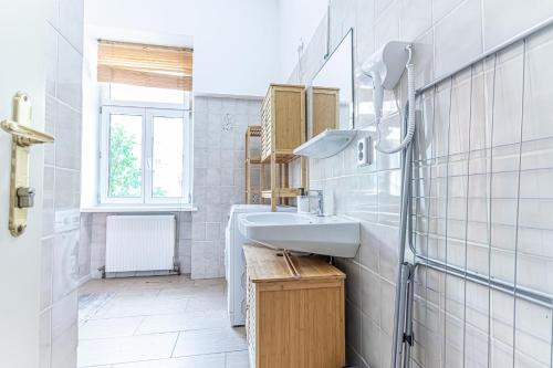 a white bathroom with a sink and a window at Convenient 3-BR Shared Apt, 15 Min to Landstraße Hub in Vienna