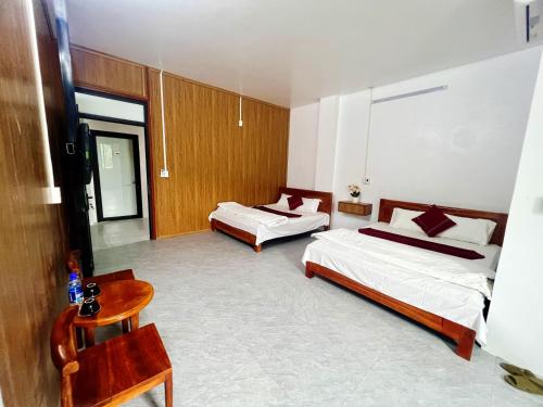 a hotel room with two beds and a table at Bảo Ngọc Motel in Làng Me