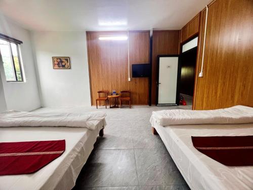 a hospital room with two beds and a table at Bảo Ngọc Motel in Làng Me