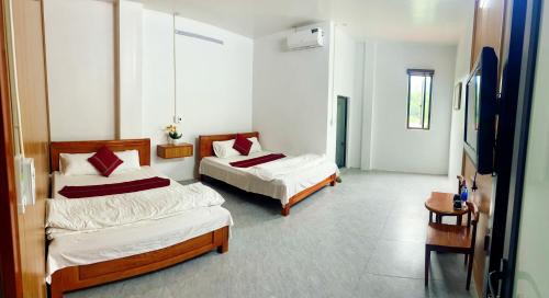 een slaapkamer met 2 bedden en een tafel bij Bảo Ngọc Motel in Ha Giang