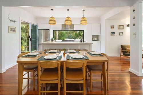 a kitchen and dining room with a wooden table and chairs at Bangalow Retreat in Buderim in Buderim