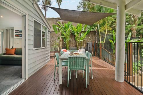 a patio with a table and chairs on a deck at Bangalow Retreat in Buderim in Buderim