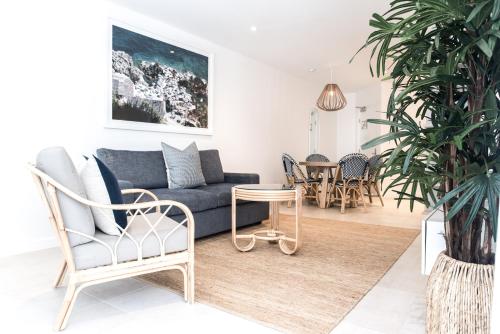 a living room with a couch and a table at On The Beach Noosa Resort in Noosa Heads