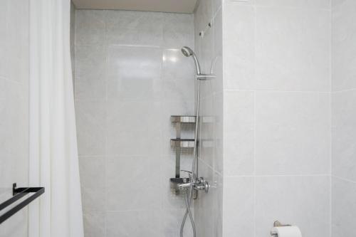 a bathroom with a shower with a shower head at Cozy and Spacious 1BR Apartment at Parkland Avenue By Travelio in Tangerang