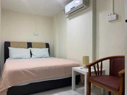 a small bedroom with a bed and a chair at CuteHomes KB in Kota Belud