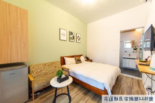 a small bedroom with a bed and a couch at Jinguann B&B in Hualien City