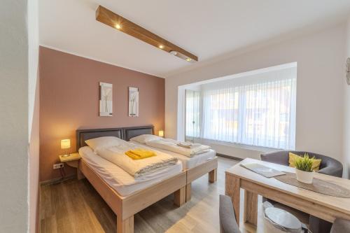 a bedroom with two beds and a table and a desk at Familienhof Brüning - Doppelzimmer Waldesruh II in Meppen