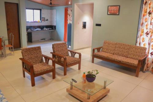 a living room with two chairs and a table at Orchid View Villa Mahabaleshwar 2 Bhk Villa in Mahabaleshwar
