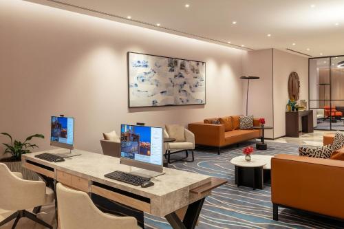 a lobby with a desk with two computers on it at Sheraton Mall of the Emirates Hotel, Dubai in Dubai