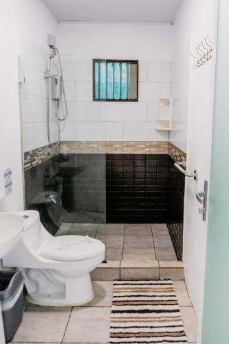 a bathroom with a toilet and a sink at Ocean's Breeze Apartment and Rooms in Puerto Viejo