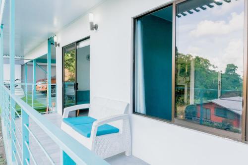 a balcony with a chair and large windows at Ocean's Breeze Apartment and Rooms in Puerto Viejo