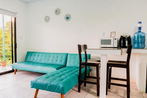 a living room with a blue couch and a table at Ocean's Breeze Apartment and Rooms in Puerto Viejo