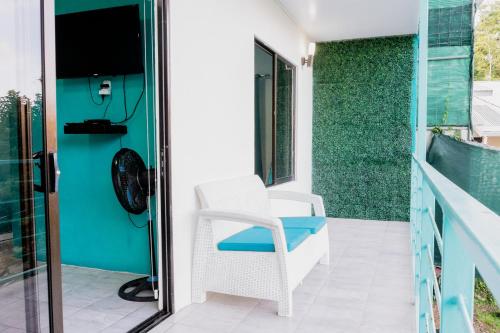 a porch with a white chair and a window at Ocean's Breeze Apartment and Rooms in Puerto Viejo