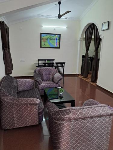 a living room with two chairs and a table at Whispering Waves Luxury Homes in Majorda
