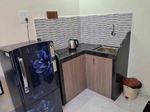 a small kitchen with a sink and a refrigerator at Whispering Waves Luxury Homes in Majorda
