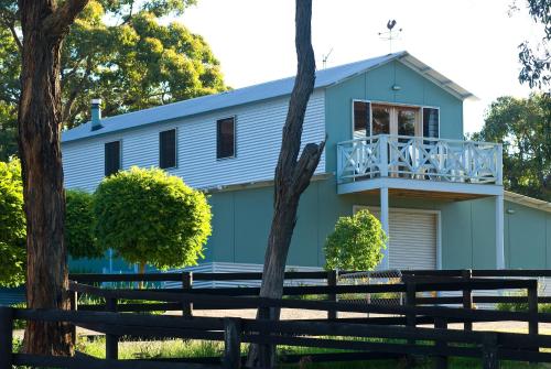 una casa azul con balcón en la parte superior en Howards Hill Retreat, en Boneo