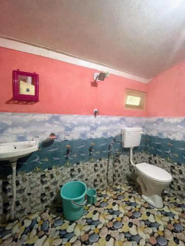 a bathroom with a toilet and a sink and a sink at Montavilla Eden Homestay Sittong in Kurseong