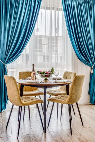a dining room with blue curtains and a table and chairs at ARI - AFI Mall Luxurious Apartments with Free Parking in Arad