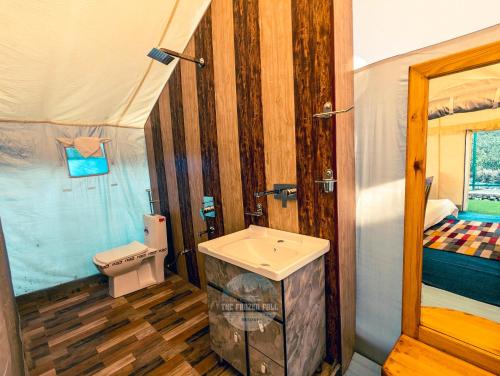 a bathroom with a sink and a toilet in a room at Dawat-e-Drung by FrozenFall Resort in Gulmarg