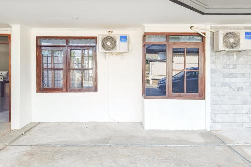a white door and windows on a building at RedDoorz at Anjasmoro Guest House near Bandara Ahmad Yani Semarang in Kalibanteng-lor