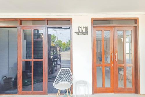 a building with two doors and a chair outside at RedDoorz at Anjasmoro Guest House near Bandara Ahmad Yani Semarang in Kalibanteng-lor