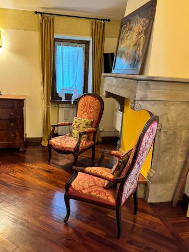 a living room with two chairs and a fireplace at Casale La Quercia in Poggio Bustone
