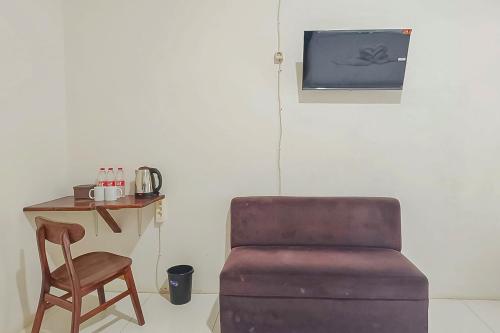 a chair and a table with a chair and a table with a chair at RedDoorz at Anjasmoro Guest House near Bandara Ahmad Yani Semarang in Kalibanteng-lor