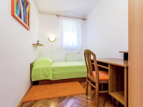 a small room with a desk and a green bed at Apartment in Pomer near the Beach in Pomer
