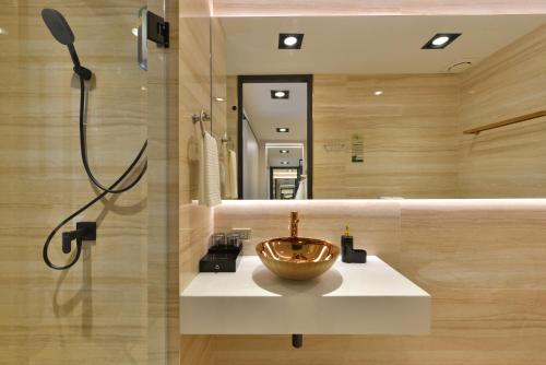 a bathroom with a bowl on a sink in front of a mirror at Victora Hostel in Bangkok
