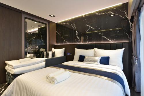 two beds in a hotel room with a mirror at Victora Hostel in Bangkok