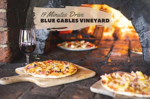 three pizzas and a glass of wine in a brick oven at Banjos Cabin Gippsland - Luxury Eco Stay - King Bed, Pond Valley Views, Fireplace in Seaton